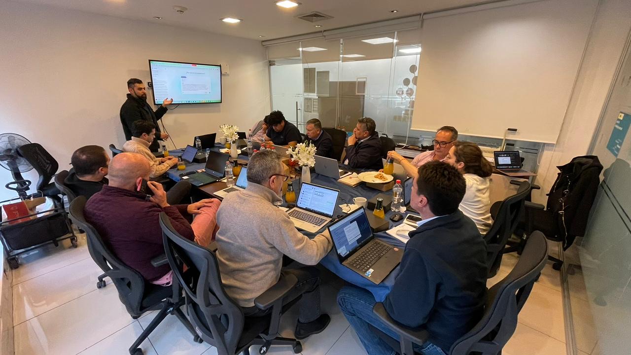 Francisco Baeza facilitando taller de IA generativa para empresa con equipo gerencial en sala ejecutiva